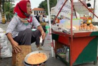Mpok Yati, penjual kerak telor yang telah berjualan kerak telor selama 10 tahun di kawasan Kota Tua, Jakarta, mengaku lebih memilih kawasan ini karena sudah pasti pangsa pelanggannya, yakni para wisatawan. Foto: Seni Budaya Betawi
