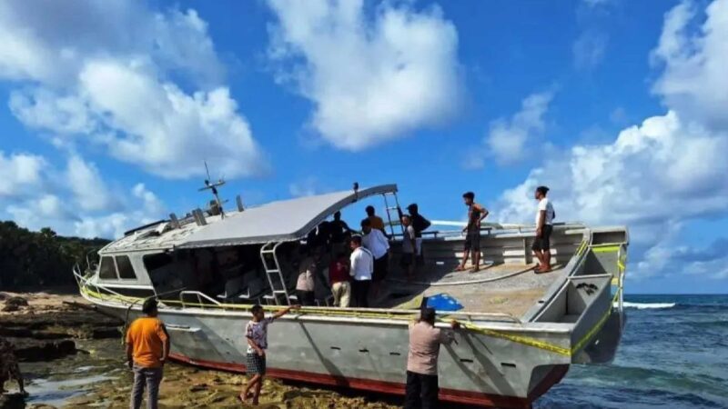 Polisi memasang garis polisi di salah satu kapal yang digunakan para WNA saat terdampar di pesisir pantai Rote Ndao, NTT, Selasa (9/7/2024). Foto: Polres Rote Ndao/Antara
